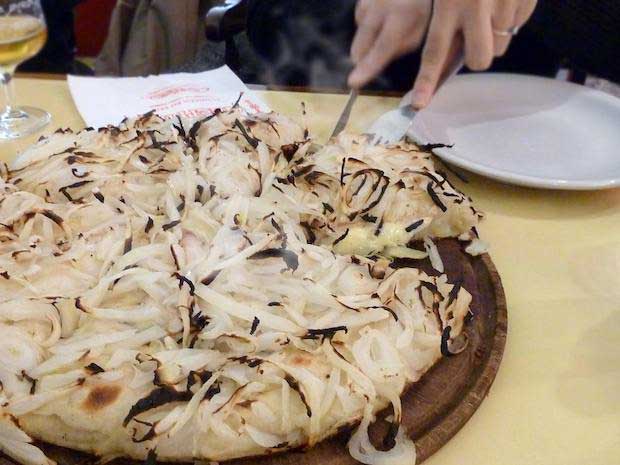 Fugazza onion style pizza on wooden plate in Guerrin pizzeria 