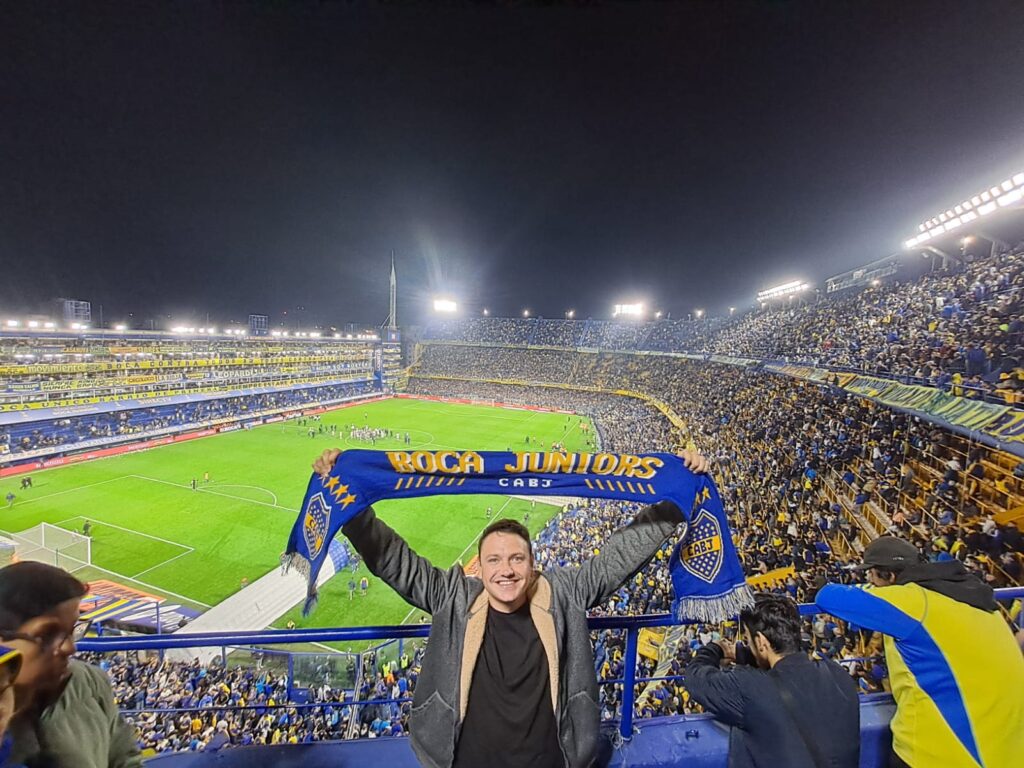 Tourist holding Boca Juniors scarf inside La Bombonera